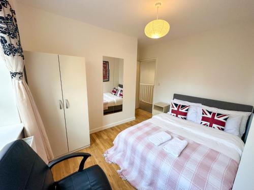 a bedroom with a bed with red and white pillows at Euston flat in London