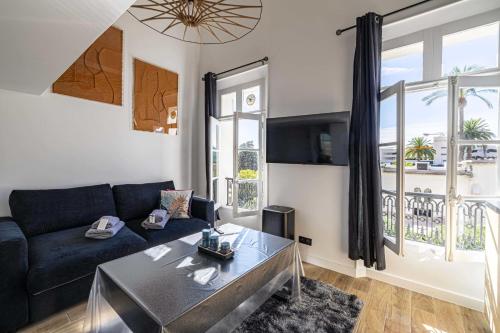 un salon avec un canapé et une table dans l'établissement Quiet apartment - parking and secure residence, à Cannes