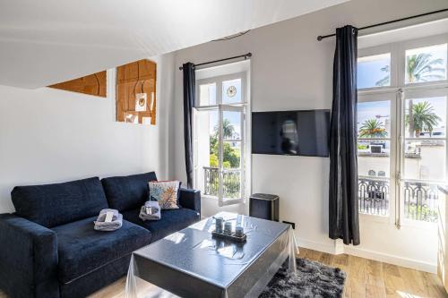 un salon avec un canapé bleu et une table dans l'établissement Quiet apartment - parking and secure residence, à Cannes