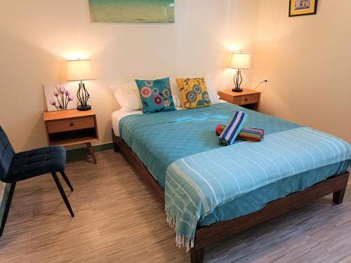 a bedroom with a bed and a chair and two lamps at Lazy Guesthouse in Vieques
