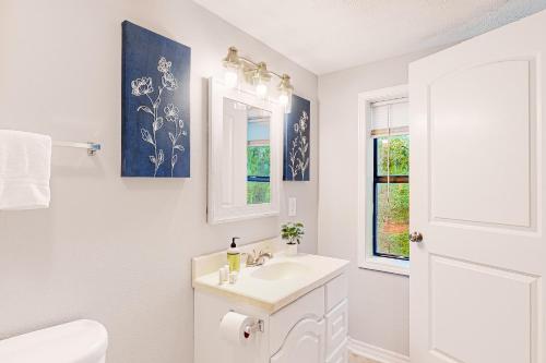a white bathroom with a sink and a mirror at La Bella Vida at Bella Vista in Bella Vista