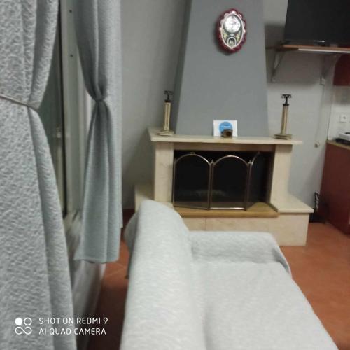 a living room with a fireplace and a couch at Guest House Sakis. in Órma