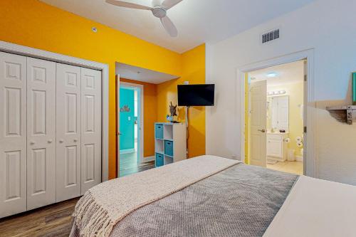 a bedroom with a bed and a yellow wall at Harbour Pointe 609 in Perdido Key