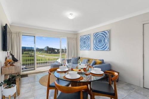 a living room with a table and a couch at Seaside Escape - Stunning Vistas over Towradgi Beach in Wollongong