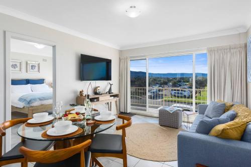 a living room with a couch and a table with a dining room at Seaside Escape - Stunning Vistas over Towradgi Beach in Wollongong