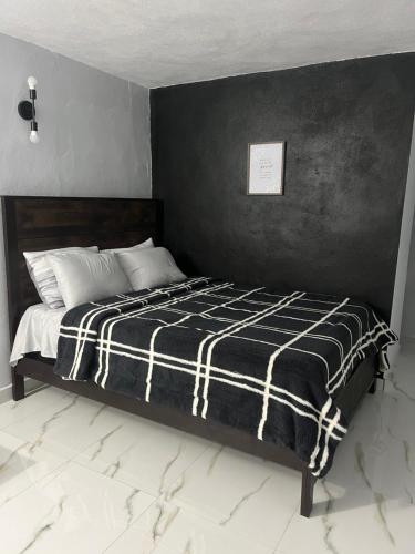 a bedroom with a bed with a black and white blanket at Molino’s House 2 in Santa Isabel