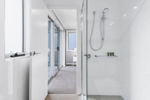 ein Badezimmer mit Dusche mit Glastür in der Unterkunft 'Harbour Escape' A Pristine Beachside Lifestyle in Shellharbour