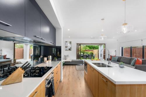 an open kitchen with white countertops and a living room at East Corrimal Escape - Beautiful Beachside Living in Wollongong