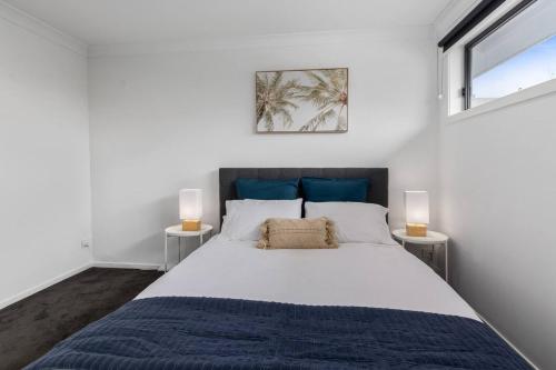 East Corrimal Escape - Beautiful Beachside Living في ولونغونغ: غرفة نوم بسرير كبير مع مصباحين