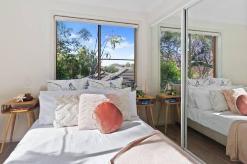 a bedroom with two beds and a large window at 'Garden Escape' Serene Coastal Living in Wollongong 