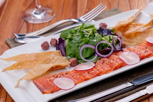 a plate of food with fish and salad on a table at Camino Real Antigua in Antigua Guatemala
