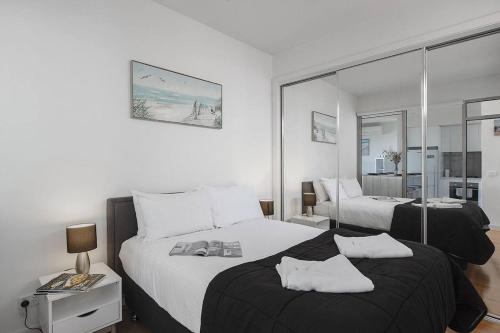 a hotel room with two beds and a mirror at Bonbeach Bliss - Contemporary Waterfront Living in Melbourne