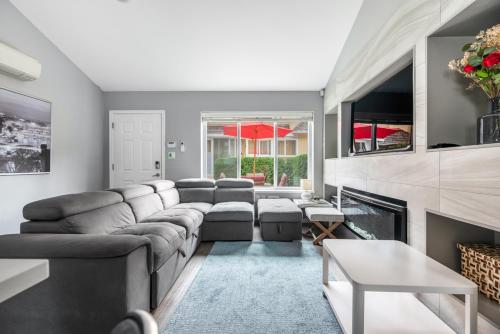 a living room with a couch and a fireplace at Stylish Dual Bedroom Suite in Van West in Vancouver