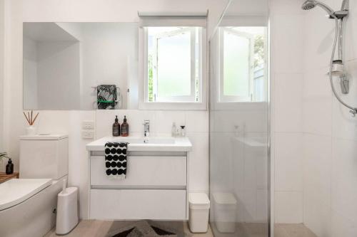 a white bathroom with a sink and a shower at Couples Corner - A Stylish Bay View Retreat in McCrae