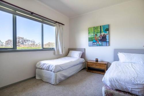 a bedroom with two beds and a window at Viewbank Homestead - A Sprawling Garden Estate in Shoreham