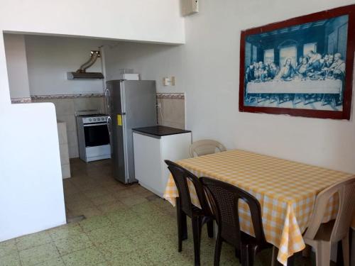 een keuken met een tafel met stoelen en een koelkast bij Departamento frente al mar in Playas