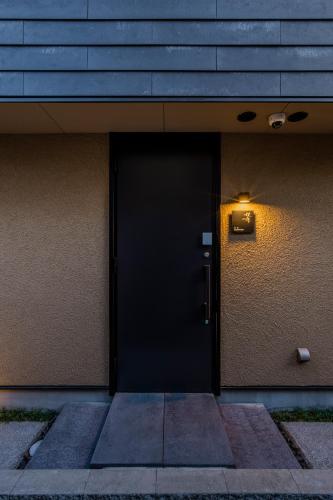 a black door with a light on the side of a building at 媛邸【ＥＮＴＥＩ】 in Matsuyama