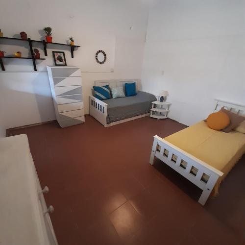 mały pokój z 2 łóżkami i łóżkiem w obiekcie OMA- Casa Temporaria w mieście Capilla del Monte