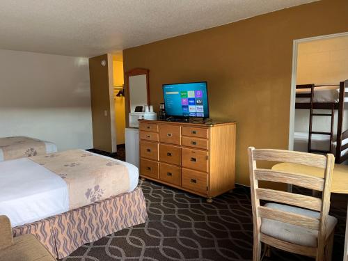 a hotel room with a bed and a television on a dresser at Americas Best Value Inn - Pendleton in Pendleton