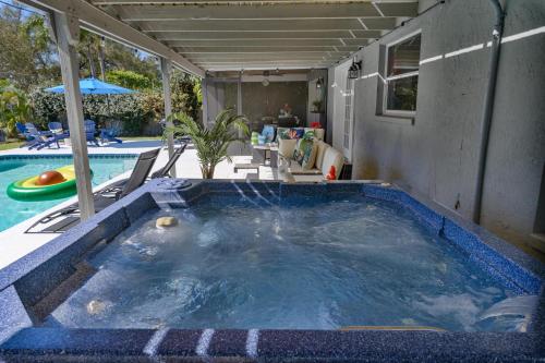een zwembad met een jacuzzi in de tuin bij Ultimate Beach Getaway · Mins from Beach · Hot Tub · Heated Pool · Game Room in Seminole