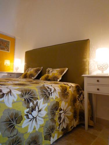 a bedroom with a bed with a yellow and white bedspread at B&B Relais Del Senatore in Polignano a Mare