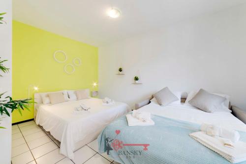- 2 lits dans une chambre de couleur verte et blanche dans l'établissement Lime Splendido x4PAX Lugano City, à Lugano