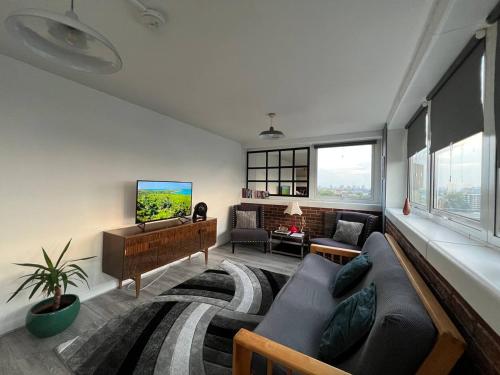 a living room with a couch and a tv at Amazing view 2 bedroom in Abbey Road in London