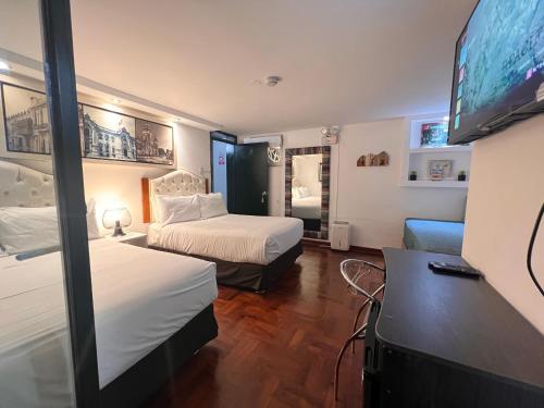 a hotel room with two beds and a flat screen tv at La Casa del Viajero in Lima