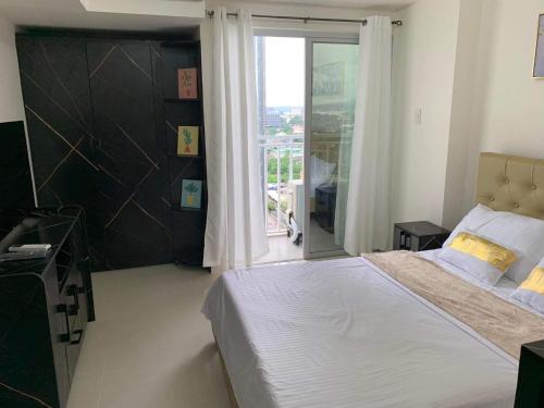 - une chambre avec un lit et une grande fenêtre dans l'établissement INSPIRIA CONDOMINIUM TOWER DAVAO, à Davao