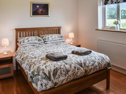 a bedroom with a bed with two pillows on it at Cedar Lodge in Old Buckenham