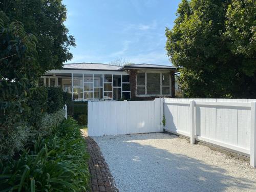 une clôture blanche devant une maison dans l'établissement HPG Villa formerly known as Pipi Hotel, à Havelock North