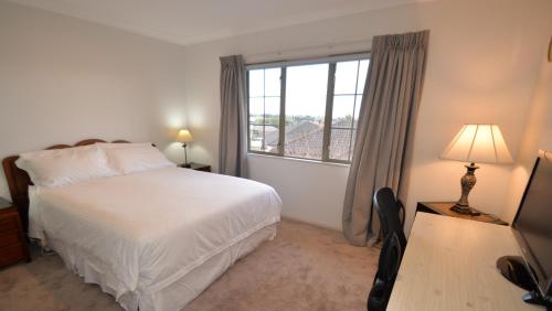 a bedroom with a bed and a large window at Tauranga Homestead Retreat in Tauranga