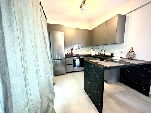 a kitchen with a black counter and a refrigerator at Villa Sunset Yerakini in Poligiros