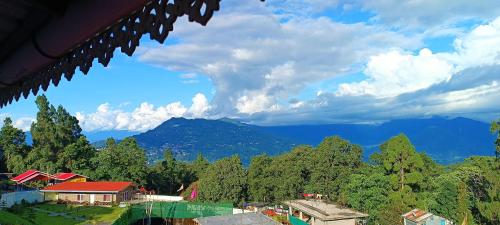 a view of a mountain with trees and houses at Mansarover Home Stay in Kalimpong