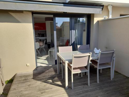 une table blanche et des chaises sur une terrasse dans l'établissement Jardin Privé et Terrasse - Appartement T2 à La Teste de Buch, Proche Plages et Activités - FR-1-319-424, à La Teste-de-Buch