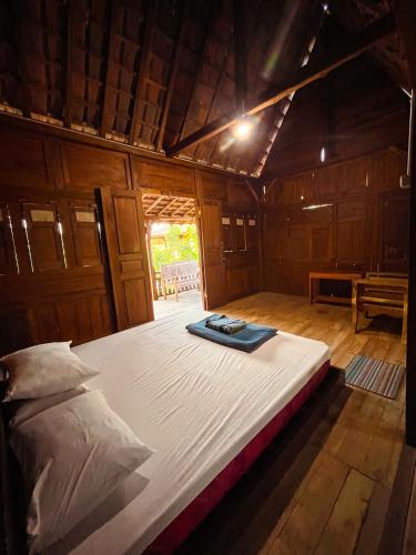 a large bed in a room with a wooden floor at Villa Kamar Tamu Bangunjiwo in Ngingas