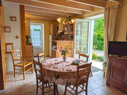 une cuisine et une salle à manger avec une table et des chaises dans l'établissement Gîte au bord de la Charente avec jardin privatif, wifi fibre, vélos et équipements familiaux - FR-1-653-162, à Saint-Genis-dʼHiersac