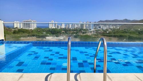 a swimming pool with a view of a city at Apartamento Turístico Santa Marta punta gaira in Santa Marta