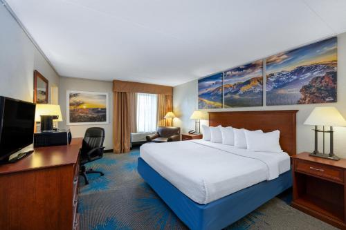 a hotel room with a large bed and a desk at Days Inn by Wyndham Casper in Casper