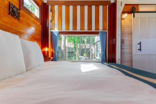 uma cama grande num quarto com uma janela em Vacation Village Okinawa - Yambaru em Nakijin