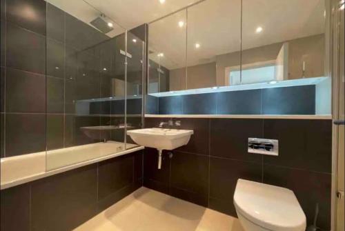 a bathroom with a toilet and a sink and a tub at Modern Room with Private Bathroom in Croydon