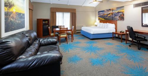 a hotel room with a couch and a bed at Days Inn by Wyndham Casper in Casper