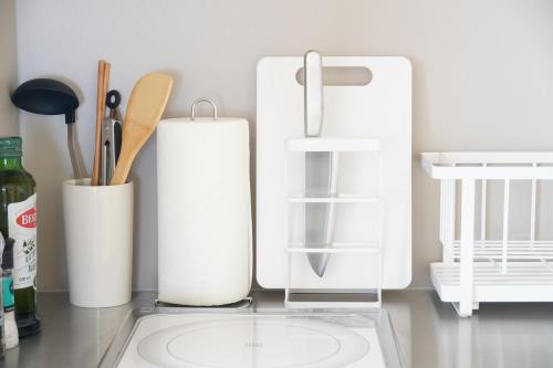 a kitchen counter with white containers and utensils at RIKKA HANASATO in Takayama