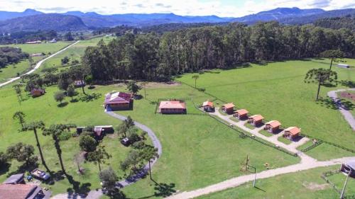 an aerial view of a large green field with buildings at Casa de Sítio Rancho crioulo in Urubici
