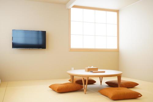 ein Wohnzimmer mit einem Tisch und einem Fenster in der Unterkunft RIKKA HANASATO in Takayama