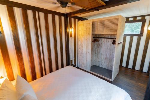 a bedroom with a white bed and a wooden wall at Vacation Village Okinawa - Nakijin in Nakijin