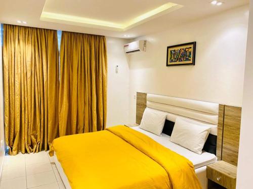 a bedroom with a yellow bed and a window at OlliebeierArtApartment Charming recently refurbished three-bedroom apartment located in VI in Lagos