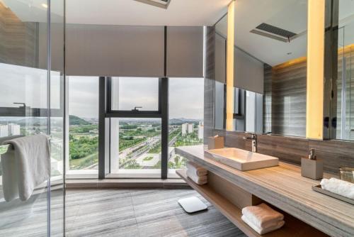 La salle de bains est pourvue d'un lavabo et d'une grande fenêtre. dans l'établissement Courtyard by Marriott Hangzhou Xihu, à Hangzhou