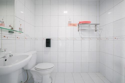 馬公市的住宿－長堤民宿，白色的浴室设有卫生间和水槽。