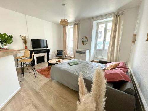 ein Schlafzimmer mit einem Bett und ein Wohnzimmer mit einem Schreibtisch in der Unterkunft La Cornaline in Vesoul